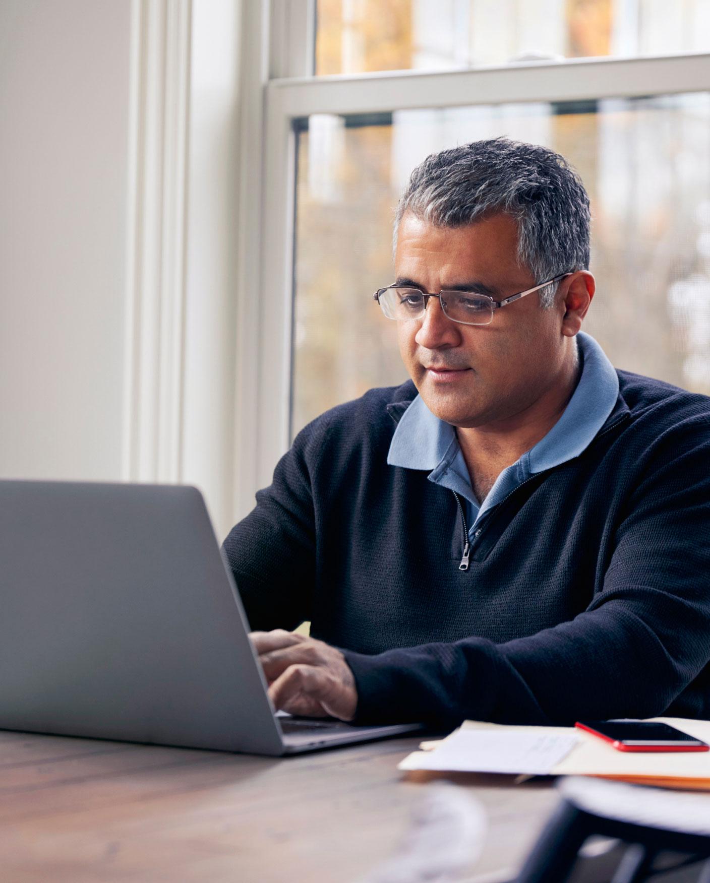 man typing on a laptop